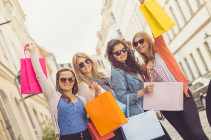 Vier junge Frauen mit Einkaufstten