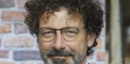 Zwei Mädchen auf einer Toilettte tauschen eine Binde