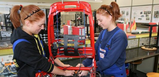 Zwei rothaarige, weibliche Auszubildenden an einem Werkstück.