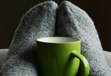 Der Generation Z ist die “Work-Life-Balance” wichtig (doch die Bedeutung differenziert) Blick auf zwei Füße in Socken um eine grüne Tasse