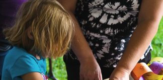 Haptische Erfahrungen fördern: “Werk.Klasse.”-Online-Ausstellung und neue Ausschreibung bastelndes Kind mit Helferin