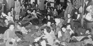 Das Foto zeigt Frauen und Kinder bei der Befreiung von Bergen Belsen - draußen türmten sich die Leichenberge. Foto: Imperial War Museum / Wikimedia Commons