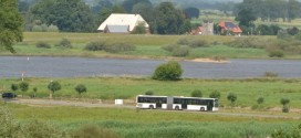 Schulbus in einer ländlichen Flusslandschaft