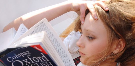 ein Mädchen, vertieft in das Oxford English Dictionary