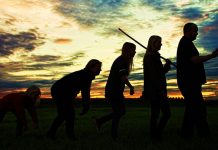 Eine Familie, die bekannte Grafik von der Entstehung des aufrechten Ganges nachstellend