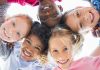 FÜnf Kinder teilweise unterschieldlicher ethnischer HErkundft stecken die Köpfe zusammen .