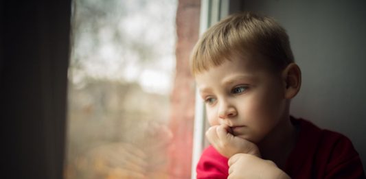 Junge blick aus dem Fenster abwärts