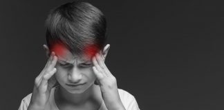 Schwarzweißbild eines Jungen, der sich die Finger an die Schläfen hält, von wo aus zwei rote Punkte über seinen Kop ausstrahlen.