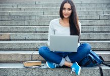 Junge Frau mit Laptop auf einer Treppe.