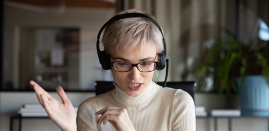 junge, gestikulierende Frau mit Kopfhörern