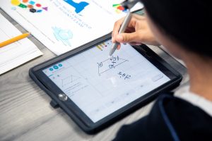 Kind schreibt mit der Hand auf iPad und nutz Magma Math