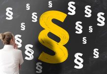 Paragrafenzeichen auf Tafel, Frau blickt nachdenklich darauf