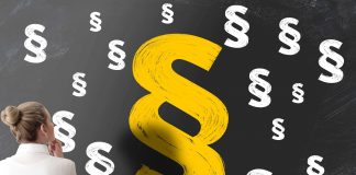 Paragrafenzeichen auf Tafel, Frau blickt nachdenklich darauf