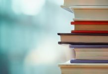 Städte- und Gemeindebund: “Wir brauchen künftig keine Schulbücher mehr” Ecke eines Bücherstapels vor unscharfem, tiefem Hintergrund