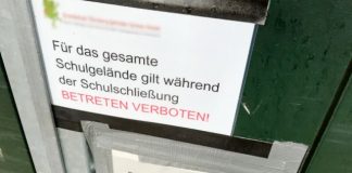 Close-up eines Hinweises an einem Schultor während der Corona-Pandemie: „Für das gesamte Schulgelände gilt während der Schulschließung Betretungsverbot - Dieser Schul(spiel)hof ist ab sofort gesperrt. Das unberechtigte Betreten sowie der Aufenthalt sind verboten.“
