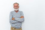 lächelnder grauhaariger, bärtiger Mann vor einem hellen Hntergrund