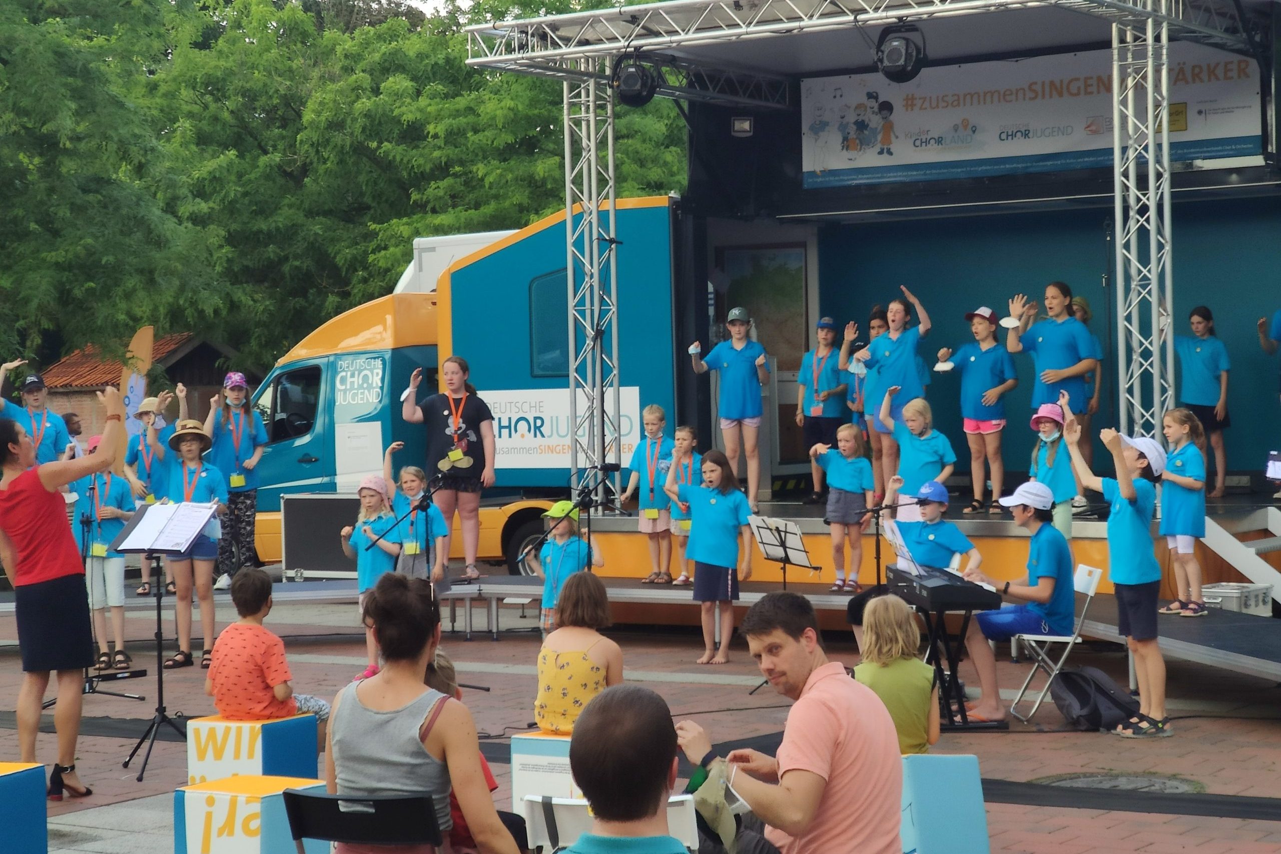 Singende Kinder auf der mobilen Bühne des Singbus Deutsche Chorjugend