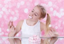 Junges Mädchen isst Marshmallows