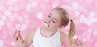 Junges Mädchen isst Marshmallows