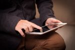 Hände auf einem tablet.