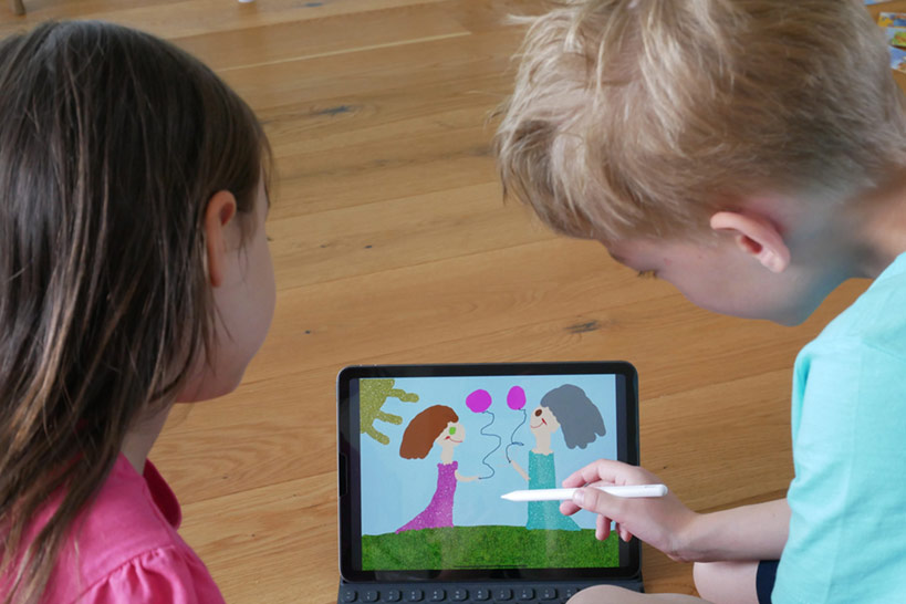 Zwei KInder betrachten Ein Bild auf einem tablet.