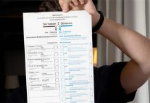 Junger Mann hinter einem Wahlzettel