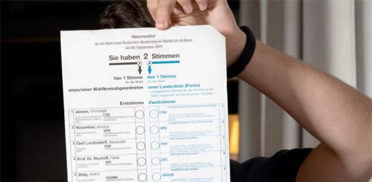 Junger Mann hinter einem Wahlzettel