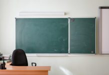 Leerer Lehrerplatz vor einer Schultafel.