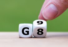 zwei Würfel nebeneinander. Sie zeigen links ein G, während der Rechte von zwei Fingern gerade von 8 auf 9 gedreht wird.