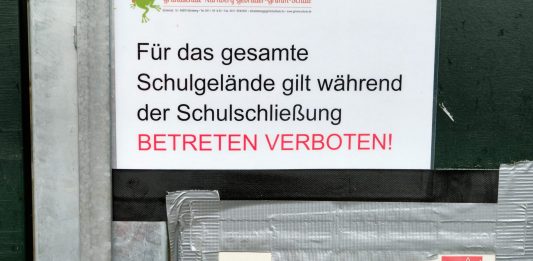 Close-up eines Hinweises an einem Schultor während der Corona-Pandemie: Für das gesamte Schulgelände gilt während der Schulschließung Betretungsverbot"