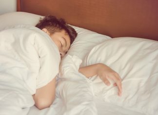Erfolgreiches Gleitzeit-Modell: Wenn Schüler den Beginn ihres Unterrichts selbst bestimmen Schlafender Junge unter der Bettdecke
