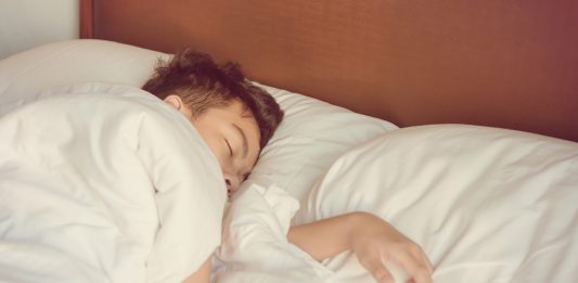 Schlafender Junge unter der Bettdecke