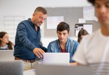 Angehende Lehrkräfte werden (noch immer) nicht ausreichend auf eine digitale Schule vorbereitet – Hochschulrektoren schlagen Alarm Ein Lehrer schaut mit einem Schüler gemeinsam auf ein Laptop.