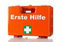 Erst Hilfe Koffer, orange mit weißem Kreuz auf grünem Grund