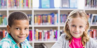Junge, Mädchen mit Tablets in Schule, lächelnd.
